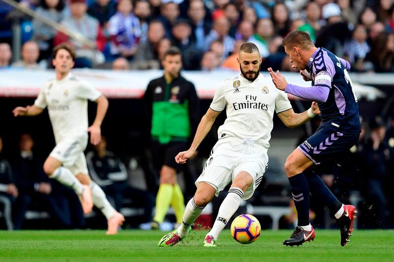 Real Madrid's Karim Benzema vies with Real Valladolid's Ruben Alcaraz. AFP