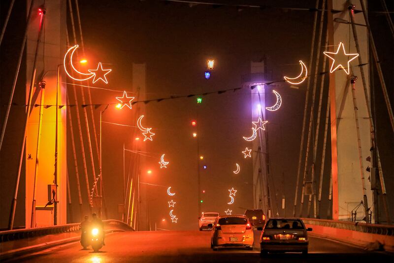Drivers pass under Ramadan decorations on Hadarat Bridge during a dust storm in Nasiriyah, southern Iraq. AFP