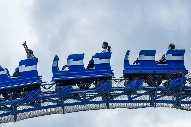 Visitors wearing protective masks ride on a roller coaster at Ocean Park during the theme park's reopening in Hong Kong, China. Bloomberg