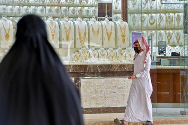 A Saudi man, wearing a protective mask, walks past a jewellery shop in Riyadh. Saudi Arabia's non-oil private sector economy improved slightly in April, but remained in contraction territory. AFP