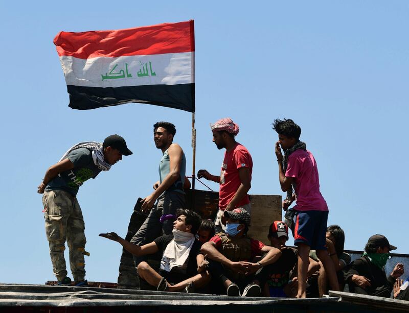 Iraqi protesters carry the Iraqi national flag as they gather on the Al-Jumhuriya bridge, which leads to the headquarters of the Iraqi government inside the high security Green Zone area, during a protest in Baghdad, Iraq.  EPA