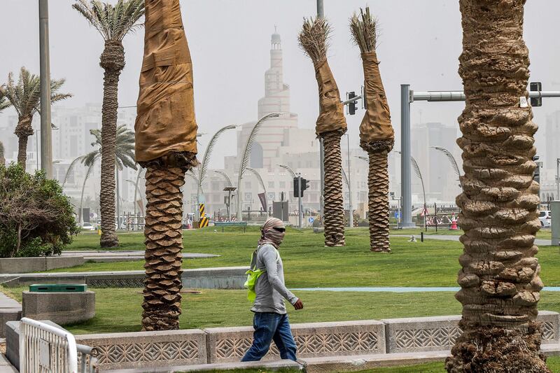 A man covers his face with a scarf in Doha during a heavy dust storm. AFP