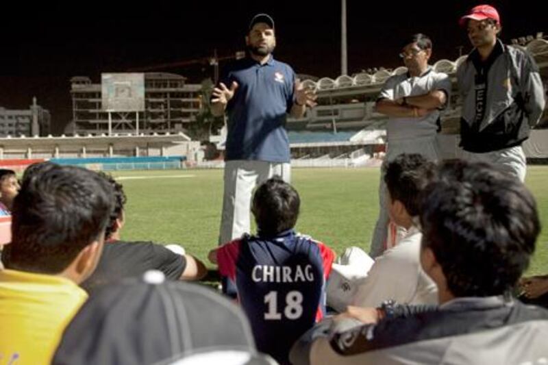 Kabir Khan, the UAE cricket team’s head coach, talks with players during practice in the Sharjah cricket stadium last month.