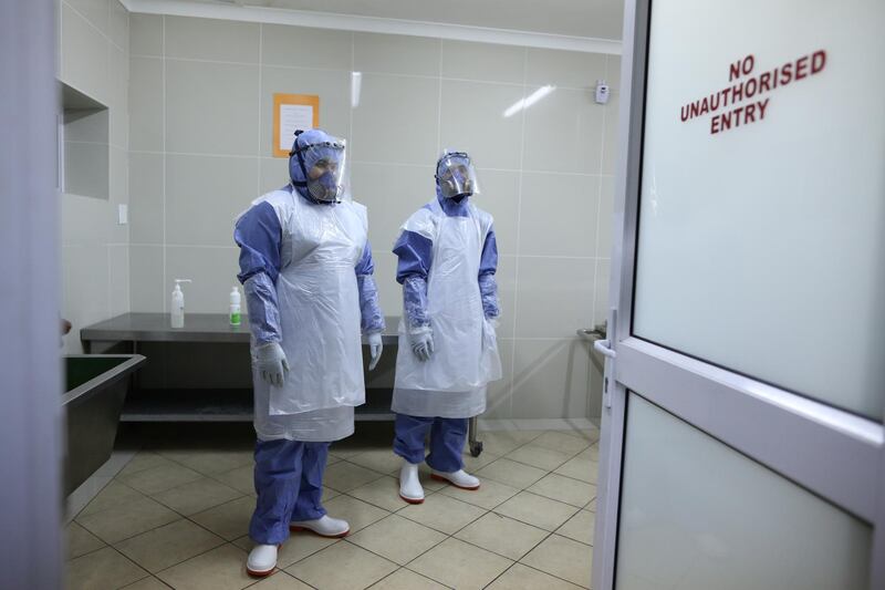 Members of the Muslim burial organization wait to prepare the body of a man who died due to the coronavirus disease (COVID-19) for burial at Ghiedmatiel Islamia mosque in Cape Town, South Africa, July 31, 2020. REUTERS