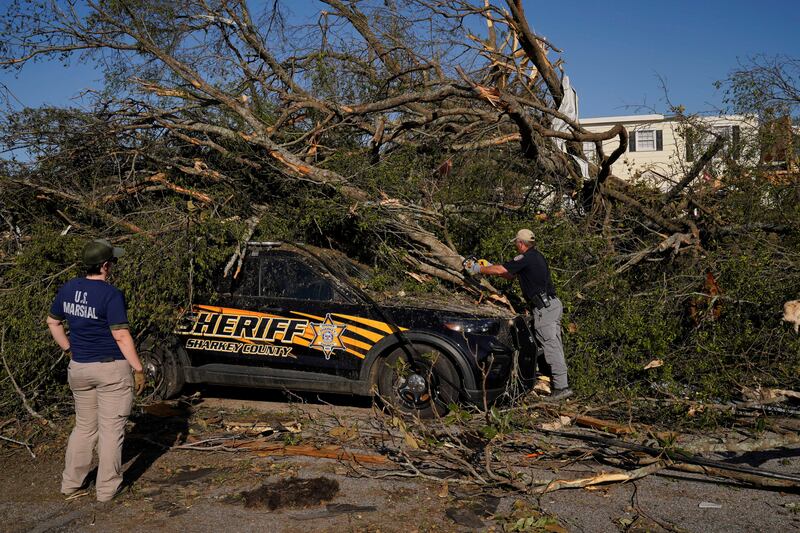 A Mississippi law enforcement officer tries to free a trapped police vehicle after tornadoes swept across the southern US state. Reuters