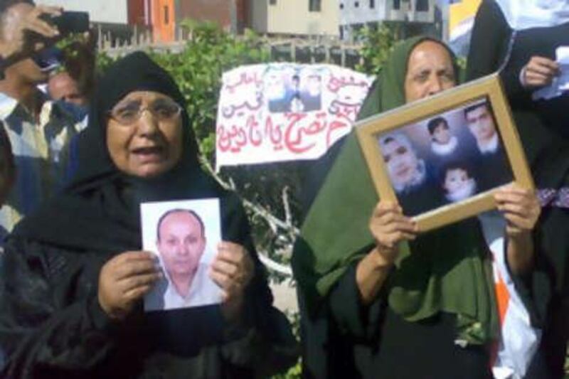 Egyptian relatives holding photographs of loved ones protest outside the court.