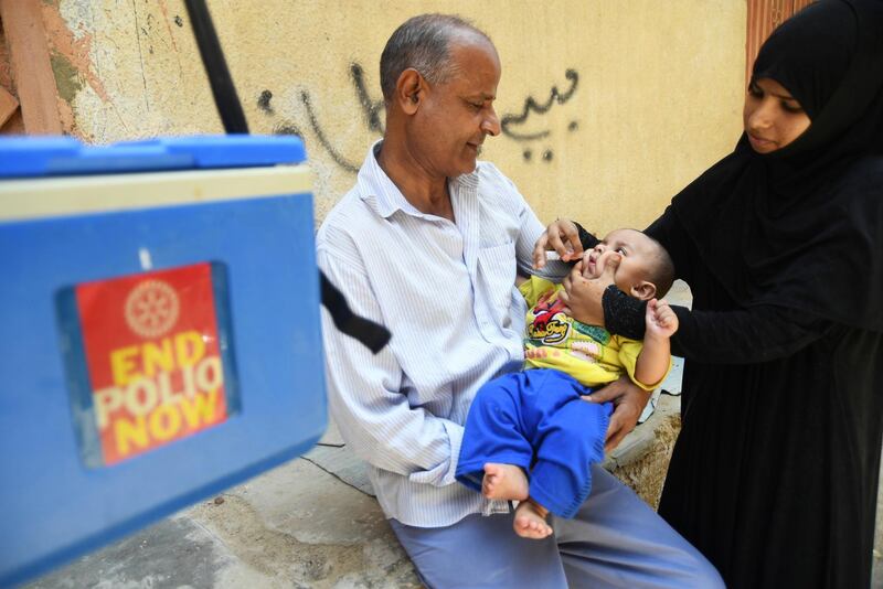 A Pakistani health worker administers polio vaccine drops to a child during a polio vaccination campaign in Karachi on May 7, 2018. - Pakistan is one of only two countries in the world where polio remains endemic. (Photo by ASIF HASSAN / AFP)
