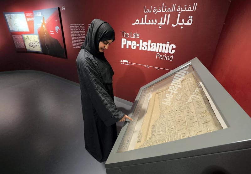 Sharjah, United Arab Emirates - July 10, 2019: Weekend's postcard section. Amna Albadri looks at a tombstone featuring bi-lingual funerary inscription in Aramaic and ancient South Arabian script, found in Mleiha at the Mleiha Archaeological Centre. Wednesday the 10th of July 2019. Maleha, Sharjah. Chris Whiteoak / The National