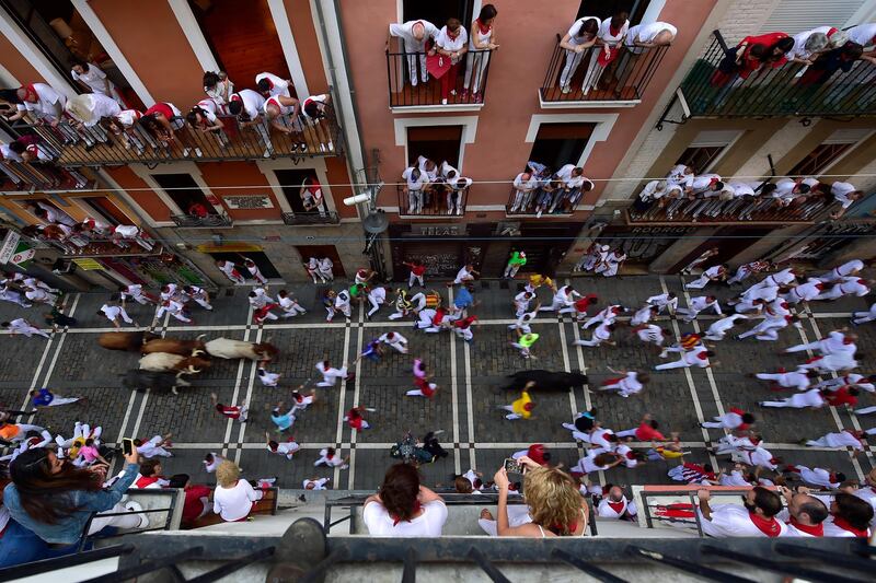 Revellers are seen from above, running next to the bulls. Alvaro Barrientos / AP Photo