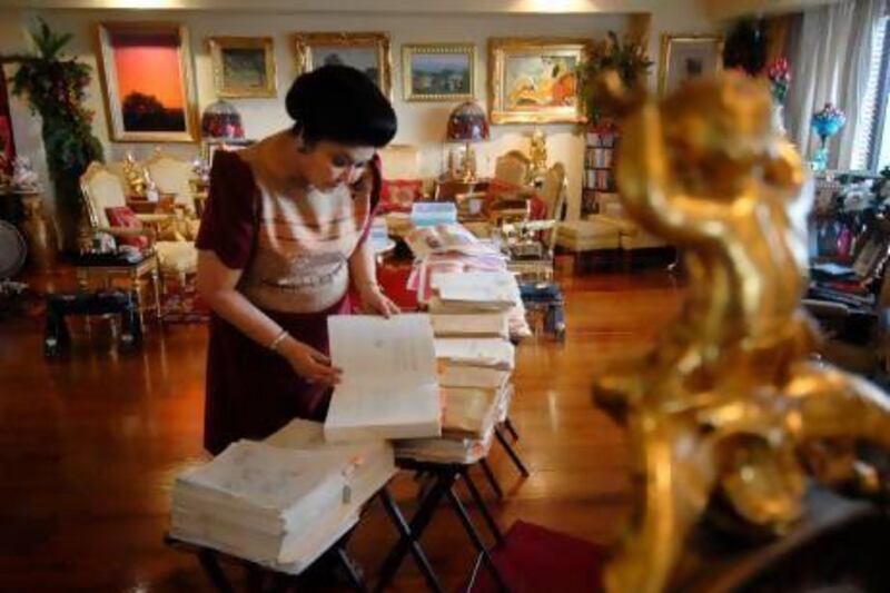 Former first lady Imelda Marcos sorts through documents of bank statements and gold certificates that she says proves the Marcos's wealth is legal.