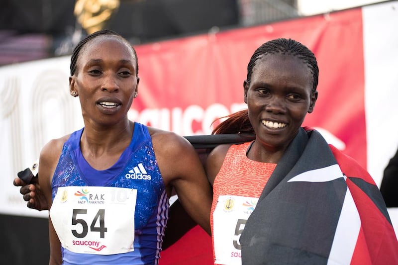Cynthia Limo, who finished first the in the women’s race takes photos with runner-up Gladys Cherono.