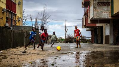 Barefoot children play football outside of a damaged stadium for the local area in Beira, Mozambique, March 22, 2019. Jack Moore / The National