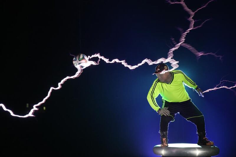 Chinese performance group LightningFan group member Wang Hongbin performing with a football as he creates lightning with a Tesla Coil. Wang Hongxin / AFP / LightningFan