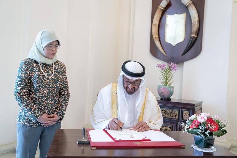 SINGAPORE, SINGAPORE - February 28, 2019: HH Sheikh Mohamed bin Zayed Al Nahyan, Crown Prince of Abu Dhabi and Deputy Supreme Commander of the UAE Armed Forces (R) sings a visitors book, prior to a meeting at, at the Istana presidential palace. Seen with HE Halimah Yacob, President of Singapore (L).
( Mohamed Al Hammadi / Ministry of Presidential Affairs )
---