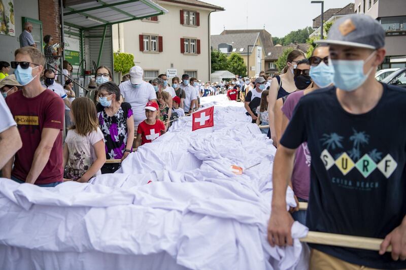 The pants, which weigh in at 700 kilograms, are carried in procession through Beromuenster during a folk festival. They were produced over eight months by Syrian tailor Xwendekar Kelesh. EPA