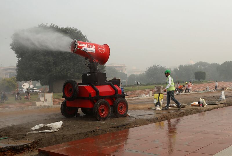 A worker is seen next to an anti-smog gun near the ongoing redevelopment project on Rajpath, on a smoggy day in New Delhi. Reuters