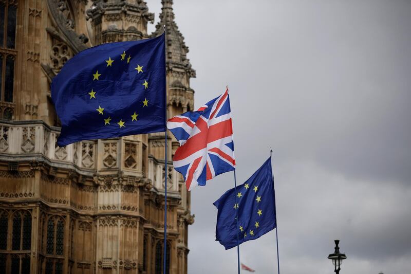 European flags and a British Union flag placed by anti-Brexit remain in the European Union supporters are blown by the wind across the street from the Houses of Parliament, not pictured, backdropped by Westminster Abbey in London, Monday, March 18, 2019. British Prime Minister Theresa May was making a last-minute push Monday to win support for her European Union divorce deal, warning opponents that failure to approve it would mean a long â€” and possibly indefinite â€” delay to Brexit. Parliament has rejected the agreement twice, but May aims to try a third time this week if she can persuade enough lawmakers to change their minds. (AP Photo/Matt Dunham)