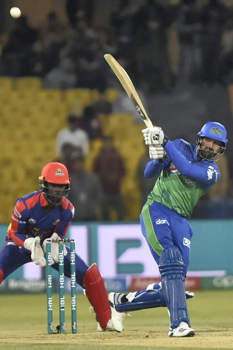 Multan Sultans' Sohail Tanvir (R) plays a shot as Karachi Kings' wicketkeeper Chadwick Walton looks on during the Pakistan Super League (PSL) T20 cricket match between Karachi Kings and Multan Sultans at the Gaddafi Cricket Stadium in Lahore on March 6, 2020. -  (Photo by Arif ALI / AFP)