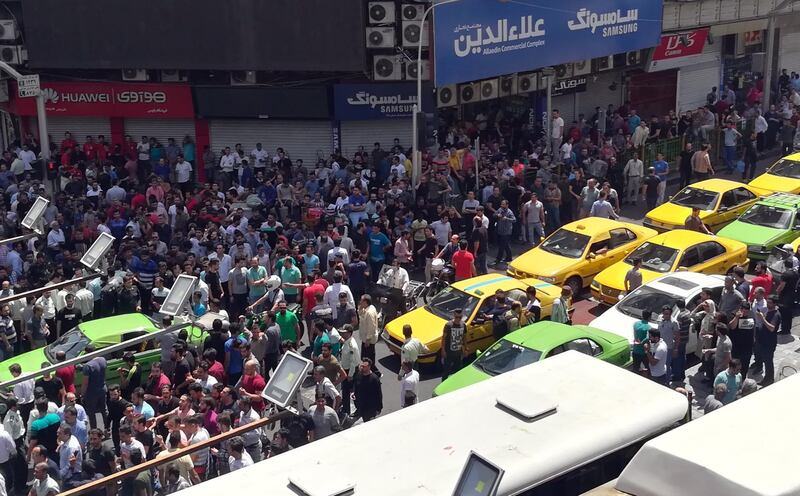 epa06839027 Iranian protestors shout slogans as they gather at a street close to a bazaar in Tehran, Iran, 25 June 2018. Media reported that due to a bad economic situation in Iran, Tehran's old grand bazaar was closed and people protests in the streets for the economic situations.  EPA/STR