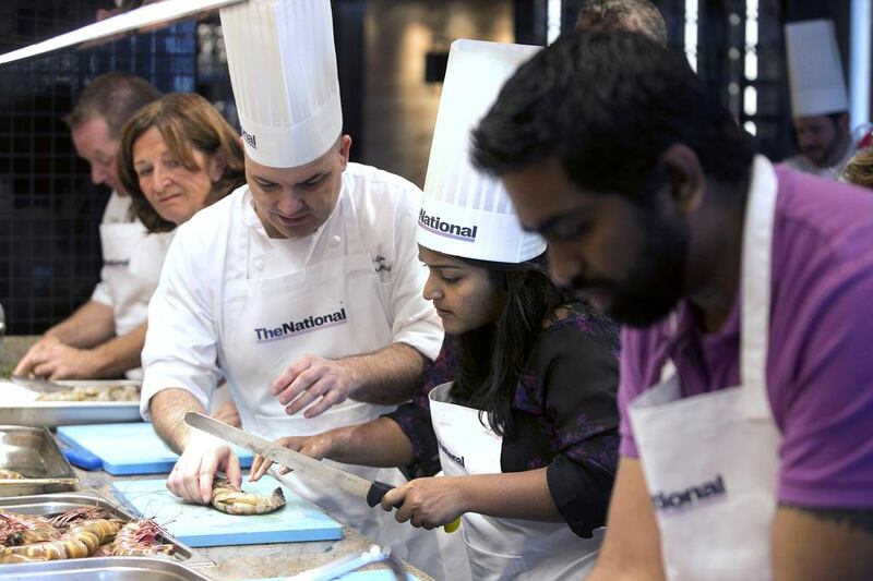 Pascal Sfara teaches the proper technique for preparation of a leader prawn to guest Yogi Karu during the #healthyliving cooking experience. Silvia Razgova / The National