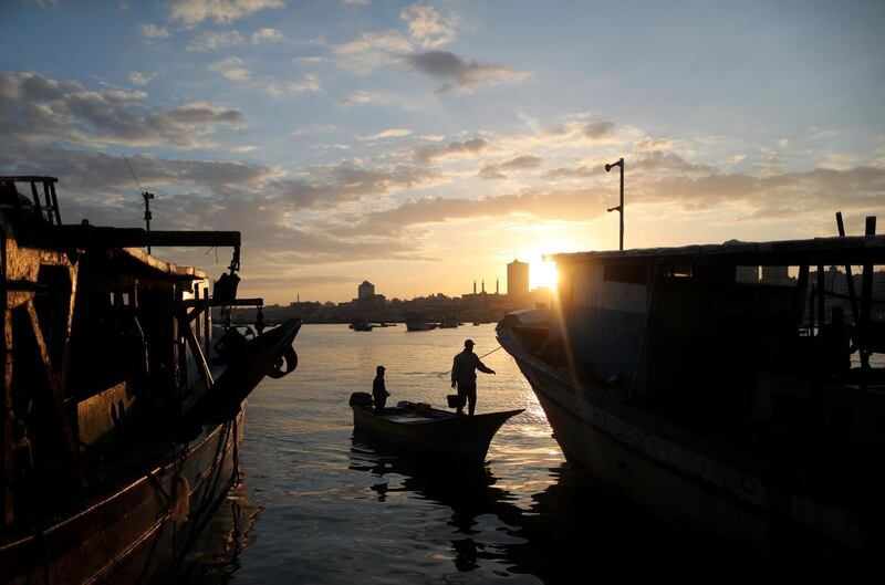 The sun rises as fishermen are seen at the seaport of Gaza City. Reuters