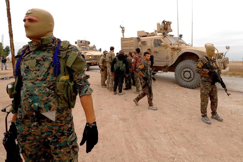 US forces and members of the Syrian Democratic Forces (SDF) patrol the Kurdish-held town of Al-Darbasiyah in northeastern Syria bordering Turkey on November 4, 2018.  Three armoured vehicles carrying soldiers wearing the US flag on their uniform arrived in the area after renewed tensions between Ankara and Syrian Kurds, a spokesman said.
Turkey last week raised threats against Kurdish forces in northeastern Syria, shelling their positions and flagging a possible new offensive.
 / AFP / Delil SOULEIMAN
