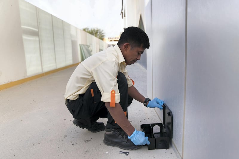 DUBAI, UNITED ARAB EMIRATES - JANUARY 3, 2019. 

Jerwil Aguirre, a pest control operator from Pro Shield Pest Control, installs a rodent bait station trap outside a building in Nad Al Hamar.

(Photo by Reem Mohammed/The National)

Reporter: Patrick Ryan
Section:  NA