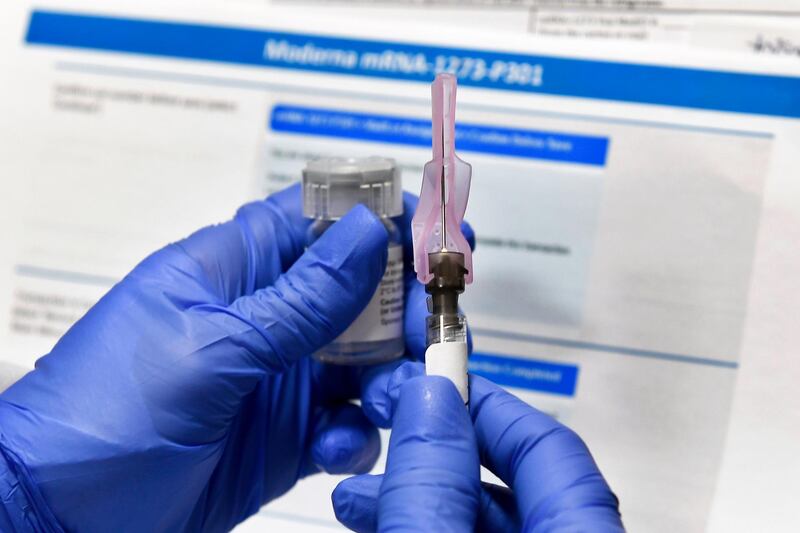 FILE - In this Monday, July 27, 2020 file photo, a nurse prepares a shot as a study of a possible COVID-19 vaccine, developed by the National Institutes of Health and Moderna Inc., gets underway in Binghamton, N.Y. On Thursday, Dec. 17, 2020, a panel of independent experts is meeting to discuss a vaccine made by Moderna. The panel's review for the Food and Drug Administration is the next-to-last step before the agency decides whether the shots can be used on an emergency basis. (AP Photo/Hans Pennink)