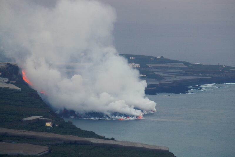 Huge clouds of white steam billow up as lava makes contact with the ocean. Photo: Reuters