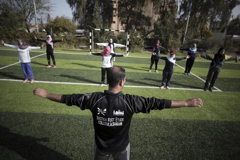 Palestinian coach Mahmoud Tafesh leads warm-up exercises.