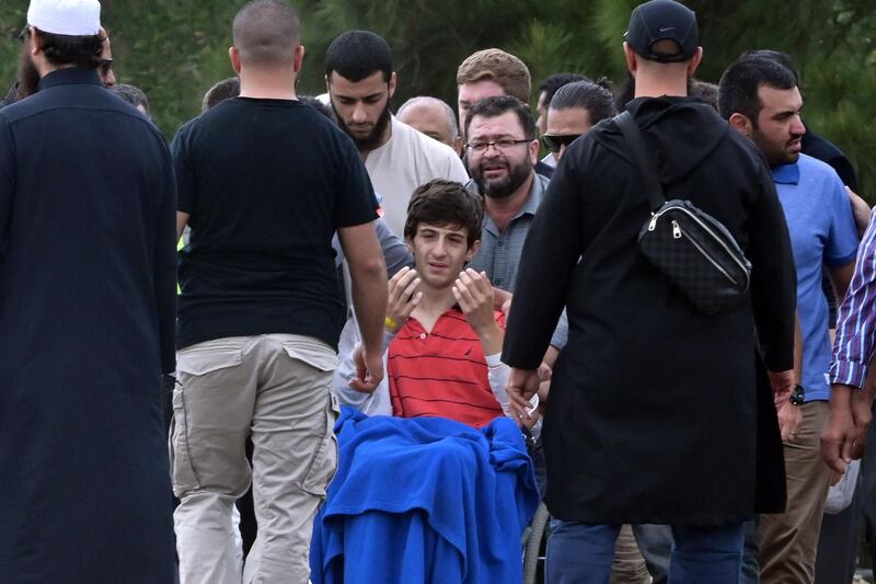 Zaid Mustafa (centre, in wheelchair), who was wounded by an Australian white supremacist gunman, prays during the funeral of his father Khalid Mustafa and brother Hamza Mustafa at the Memorial Park cemetery in Christchurch on March 20, 2019. AFP