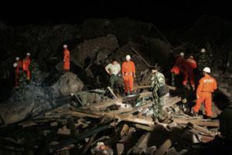 Rescue personnel search for survivors in a massive landslide in south-west China