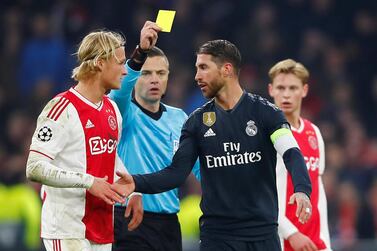 Soccer Football - Champions League Round of 16 First Leg - Ajax Amsterdam v Real Madrid - Johan Cruijff Arena, Amsterdam, Netherlands - February 13, 2019 Real Madrid's Sergio Ramos is shown a yellow card by referee Damir Skomina as Ajax's Kasper Dolberg looks on REUTERS/Wolfgang Rattay