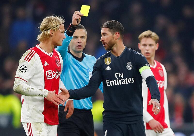 Soccer Football - Champions League Round of 16 First Leg - Ajax Amsterdam v Real Madrid - Johan Cruijff Arena, Amsterdam, Netherlands - February 13, 2019  Real Madrid's Sergio Ramos is shown a yellow card by referee Damir Skomina as Ajax's Kasper Dolberg looks on  REUTERS/Wolfgang Rattay