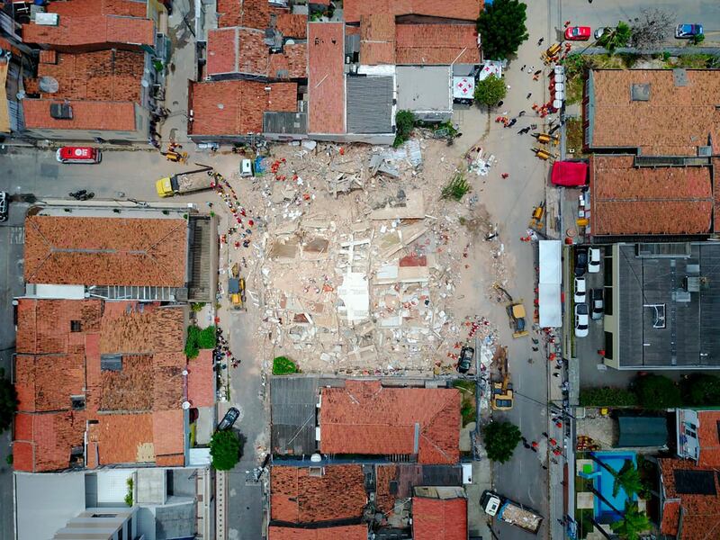 In this photo released by the Ceara state government, firefighters search for survivors at the site of a collapsed building in Fortaleza, Brazil.  AP
