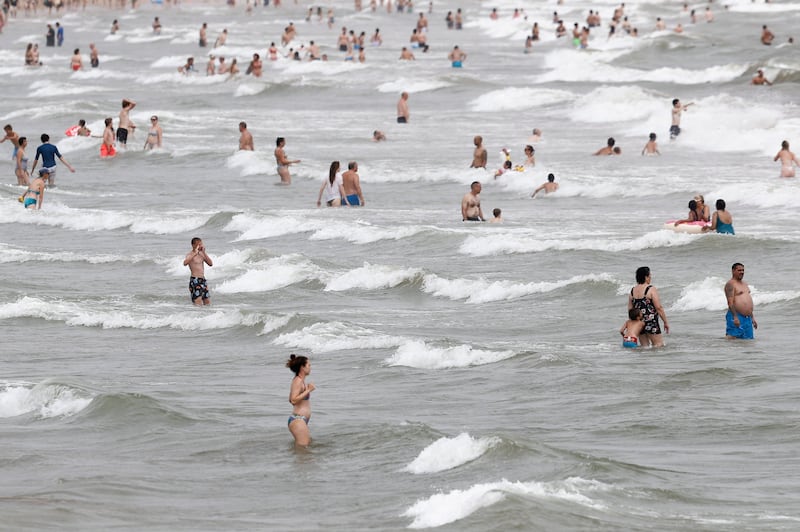 Beachgoers cool off in the ocean at a beach in Valencia, Spain. A new heat wave is to hit the country on Monday, with temperatures above 40°C expected in many places. EPA 