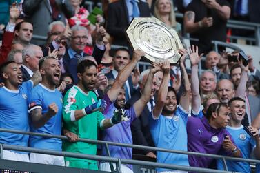 Manchester City's David Silva, centre right, and teammate Sergio Aguero hold up the Community Shield trophy on Sunday. Frank Augstein / AP Photo