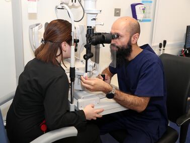 An optometrist examines a patient at the Moorfields eye hospital in Abu Dhabi. Cash-rich investment funds in the GCC are looking to life sciences, pharmaceutical and healthcare assets in the UK, the US and Europe. Pawan Singh / The National