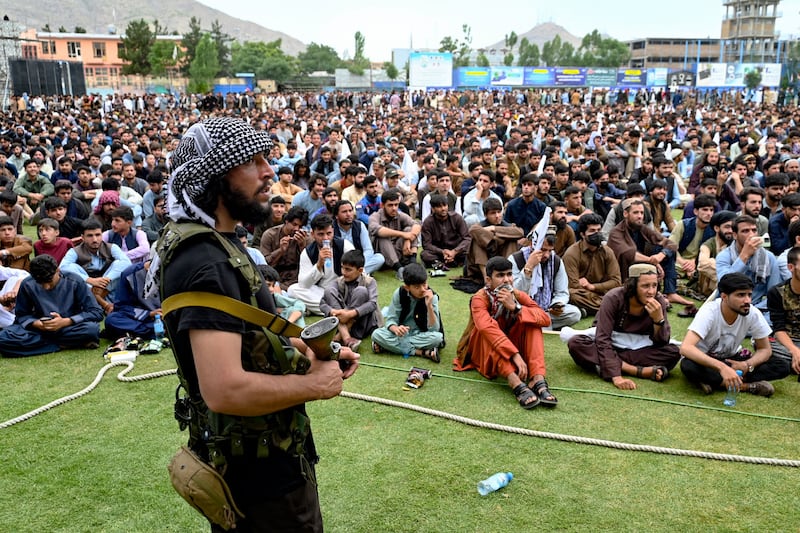 An Afghan security guard watches on as fans tune into a live broadcast of the ICC men's T20 World Cup 2024 semi-final cricket match between Afghanistan and South Africa, Kabul. AFP