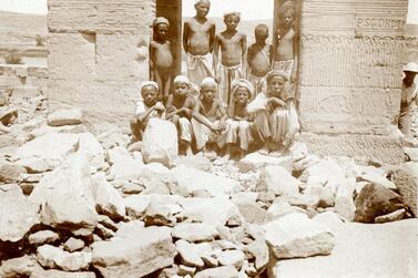 10 local boys pose at the rock-strewn entrance of the temple of Dendur