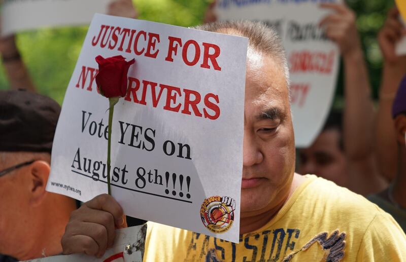 (FILES) In this file photo taken on August 07, 2018 The New York Taxi Workers Alliance holds a vigil outside City Hall  in New York in support of for-hire-vehicle cap. - New York's city council on August 8, 2018, dealt a blow to Uber and other car-for-hire companies, passing a bill to cap the number of vehicles they operate and impose minimum pay standards on drivers. (Photo by TIMOTHY A. CLARY / AFP)