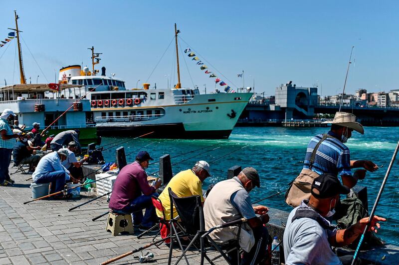 People fish next to the Bosphorus strait, at Eminonu district in Istanbul.  AFP