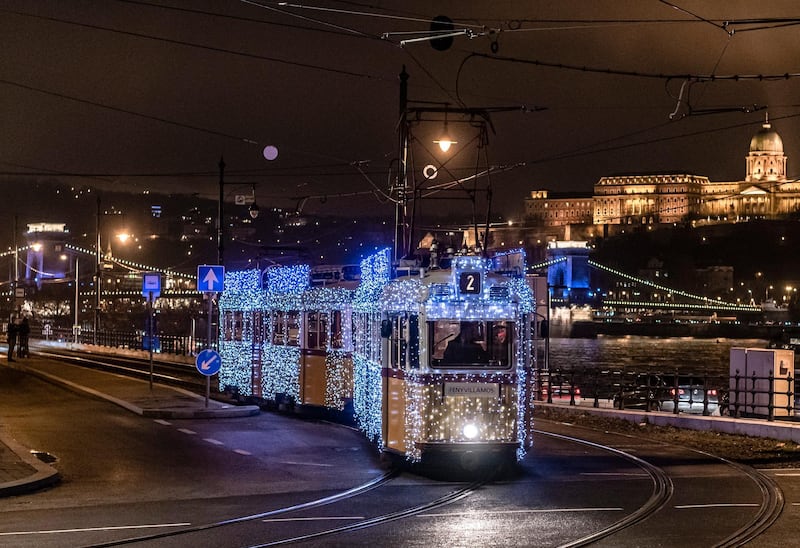 epa08033705 A tram decorated with Christmas lights passes in front of the Chain Bridge and the Royal palace in the Castle of Buda (top, right) in downtown Budapest, Hungary, 29 November 2019.  EPA/Zsolt Szigetvary HUNGARY OUT