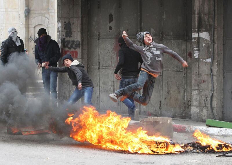 Palestinian stone throwers clash with Israeli security forces in the West Bank city of Hebron. Hazem Bader / AFP   