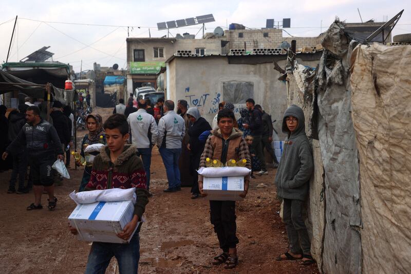 Displaced Syrians carry boxes from the UN World Food Programme before aid delivery was stopped, in the camp of Atma, Idlib, in rebel-held north-western Syria, on December 6. AFP
