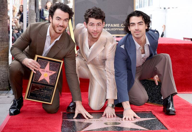 Kevin Jonas, Nick Jonas and Joe Jonas, of the Jonas Brothers, pose with their new star on the Hollywood Walk of Fame. Getty / AFP