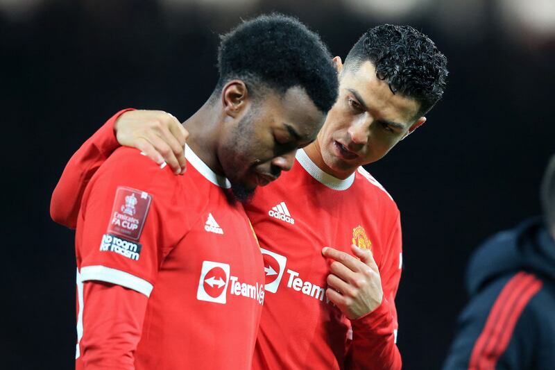 Manchester United's Portuguese striker Cristiano Ronaldo, right, consoles Swedish team mate Anthony Elanga after his penalty miss gave victory to Middlesbrough in the English FA Cup fourth round match at Old Trafford in Manchester, north-west England. AFP