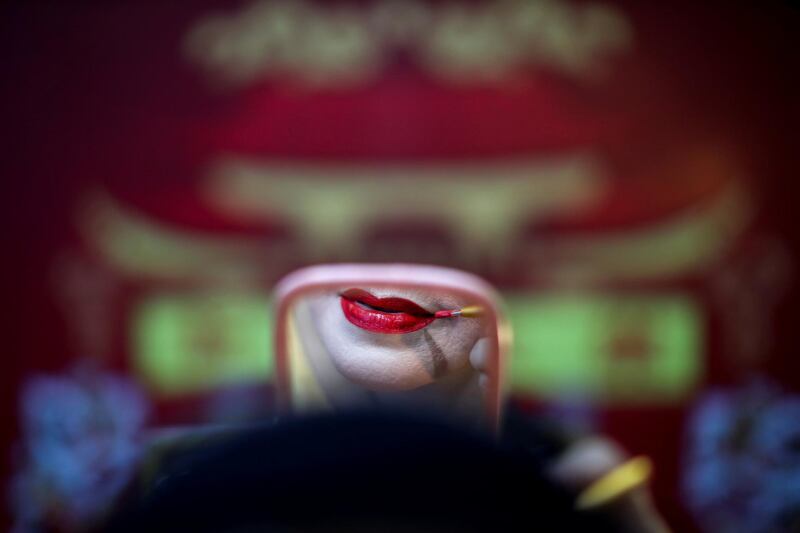 A member of a Chinese opera troupe applies make-up before performing at a shrine in Bangkok, Thailand. Reuters