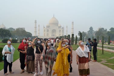 Foreign tourists wearing face masks visit the Taj Mahal under heavy smog conditions, in Agra, India. AFP