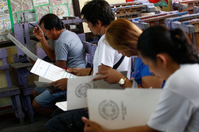 Filipinos fill out their ballots at an elementary school turned into a voting precinct in Quezon City, east of Manila, Philippines.  EPA